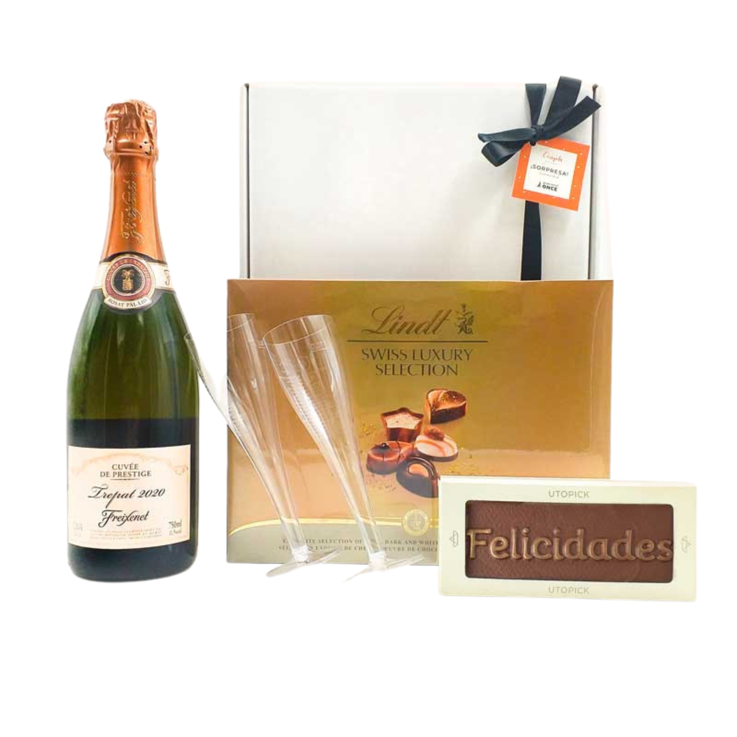 Imagen de caja regalo de color blanca y lazo negro, con botella de cava de la marca Freixenet Trepat, copa de plástico, tableta de chocolate con la palabra felicidades de la marca Utopick y bombones Lindt  image number null